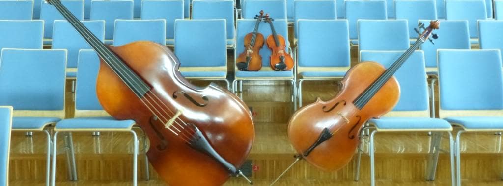 Geige, Bratsche, Cello und Bass sind auf den blauen Stühlen der Musikschule trapiert